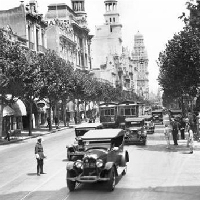 Avenida 18 de Julio en la década del 40 con cachilas y tranvía circulando. Las veredas están tupidas de árboles.