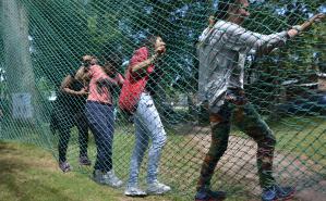 Cuatro mujeres jovenes alegres caminando sobre una red en un parque