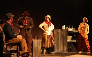 Tres hombres y una mujer actuando sobre un escenario